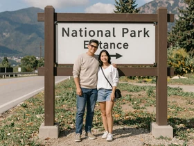 Couple posing at a national park sign - trucker dating travel adventure